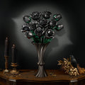 Black rose bouquet in a metal vase with candles, a raven and skulls on an antique table