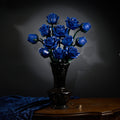 Blue rose bouquet in a carved dark vase with blue velvet drapery