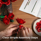 Hands assembling a red poppy stem beside the illustrated instruction sheet
