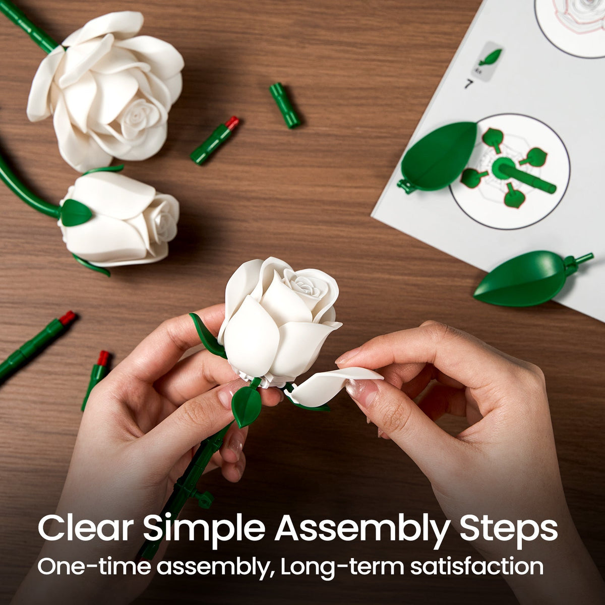 Hands clicking a white rose petal into place beside the loose pieces and the illustrated guide