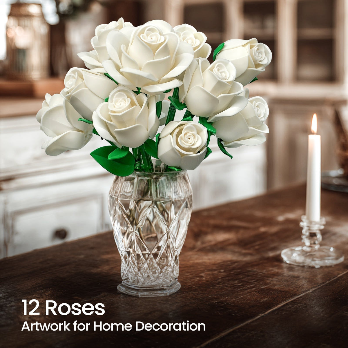Twelve white roses in a cut crystal vase beside a lit candle on a wooden table