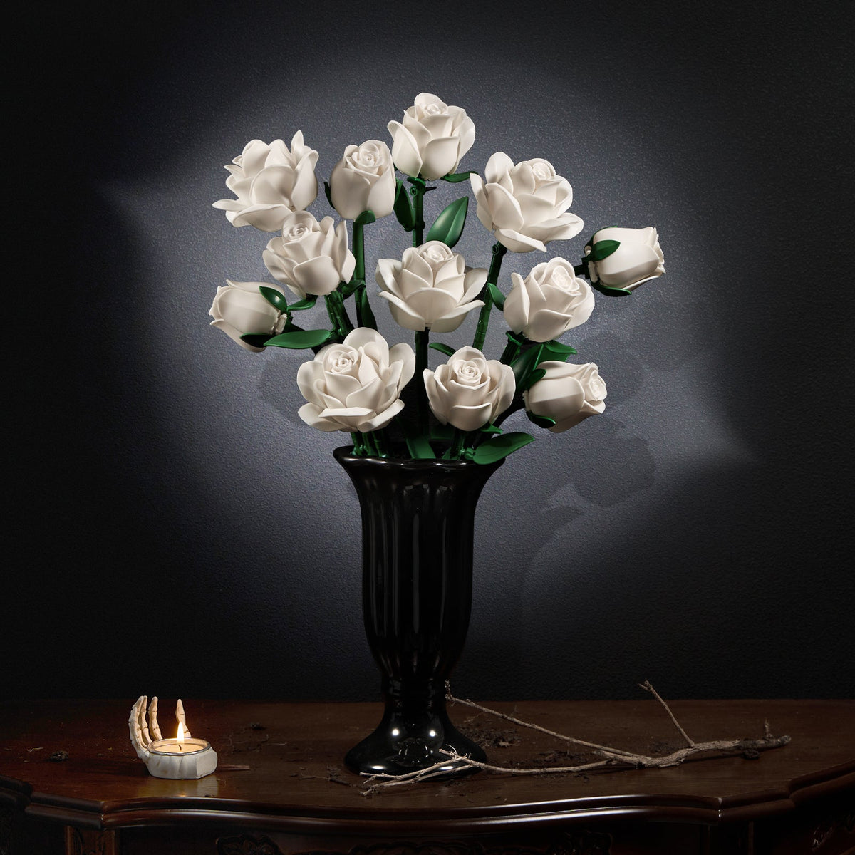 White rose bouquet in a carved black vase on an antique table against a dark background