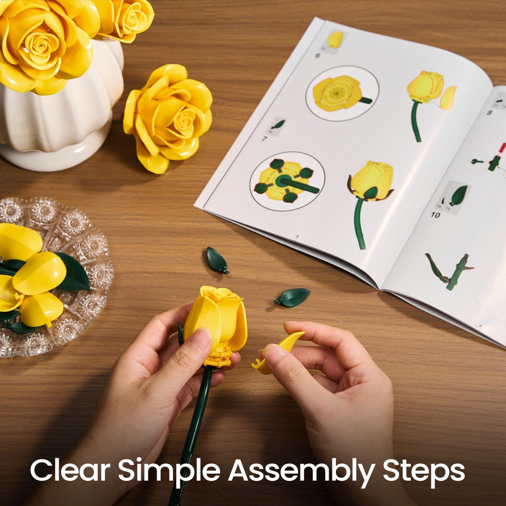 Hands assembling a yellow rose beside the open illustrated guide