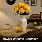 Yellow roses in a white vase on a table beside a vintage radio